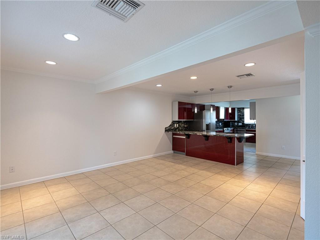 11001 Southeast Sunset Harbor Road, Unit 34 Summerfield, FL 34491 - Photo 15 of 31 Kitchen with tile floors, kitchen peninsula, backsplash, and crown molding