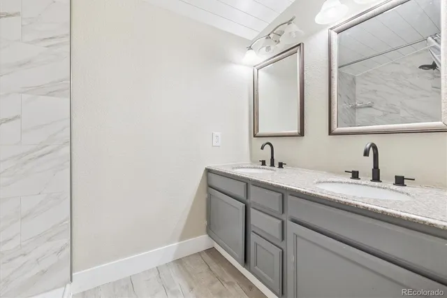 a bathroom with a granite countertop sink and a mirror