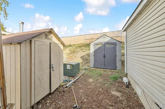 a view of a house with a small yard and wooden fence