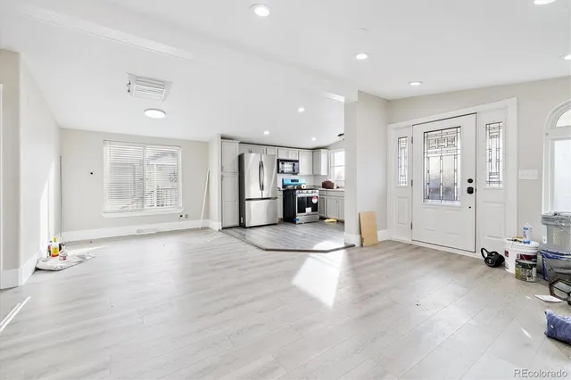 a view of empty room with wooden floor and window