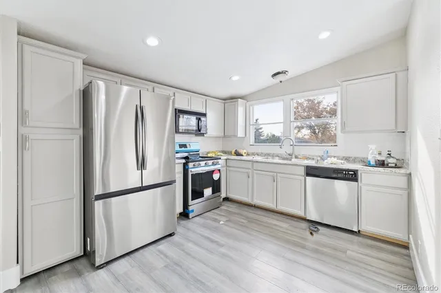 a kitchen with a refrigerator and white cabinets