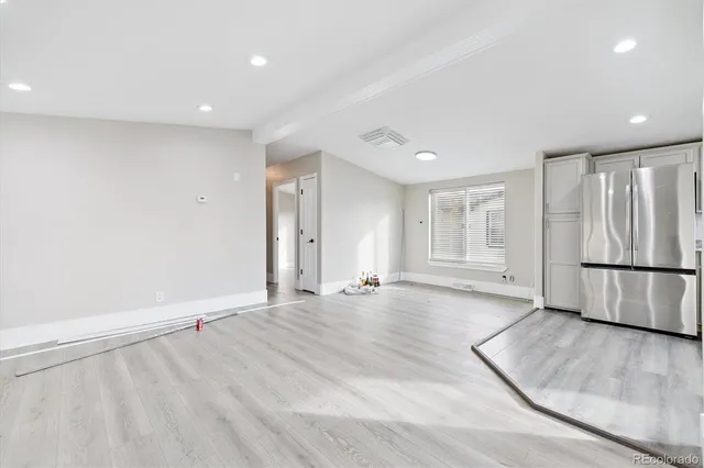a view of an empty room with a kitchen