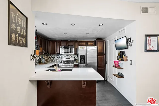 a kitchen with stainless steel appliances a sink and cabinets