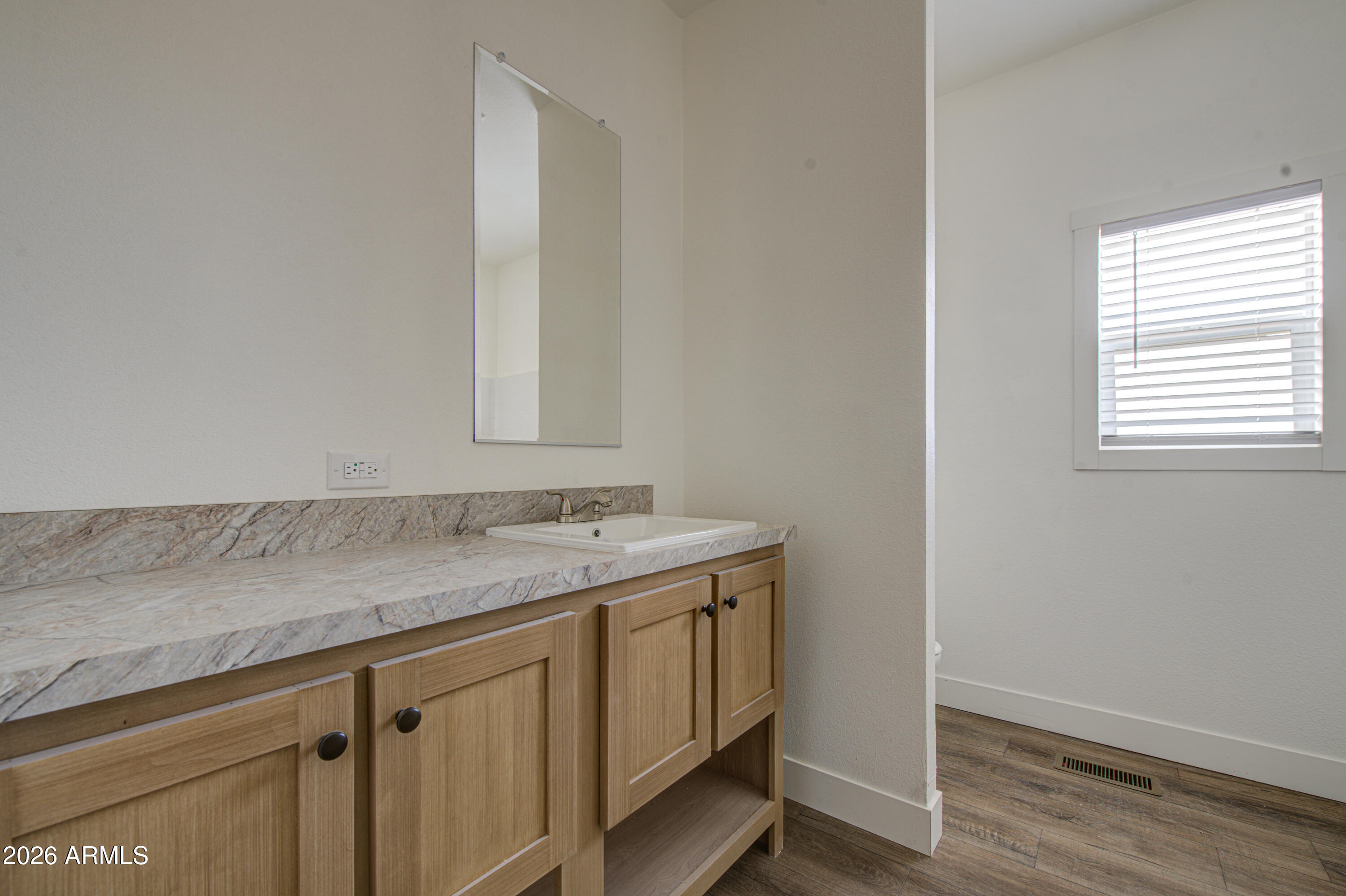 39120 West Maldonado Road Tonopah, AZ 85354 - Photo 31 of 37 a bathroom with a granite countertop sink and white cabinets