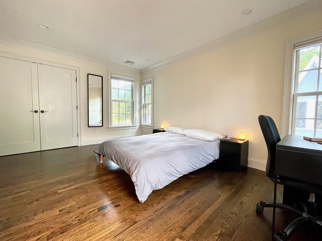 132 Rindge Avenue, Unit 1 Cambridge, MA 02140 - Photo 3 of 11 a bedroom with a bed a chair and a window