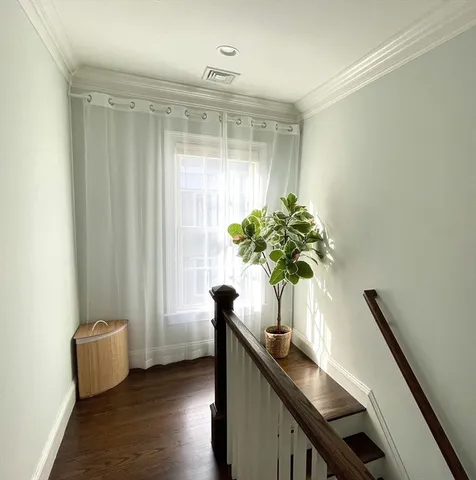 a view of a room with a large window and wooden floor