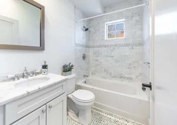 a bathroom with a granite countertop toilet sink and bathtub