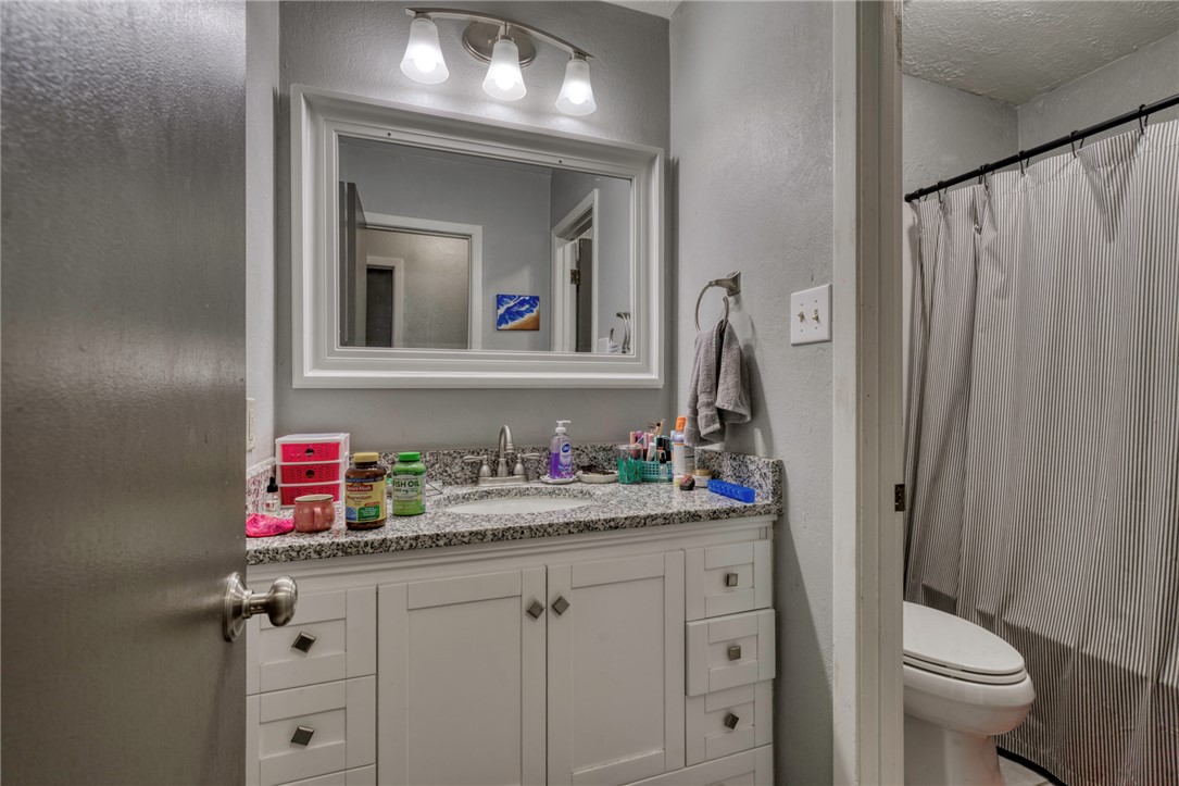 1410 Clement Court College Station, TX 77840 - Photo 11 of 16 a bathroom with a toilet sink vanity and mirror