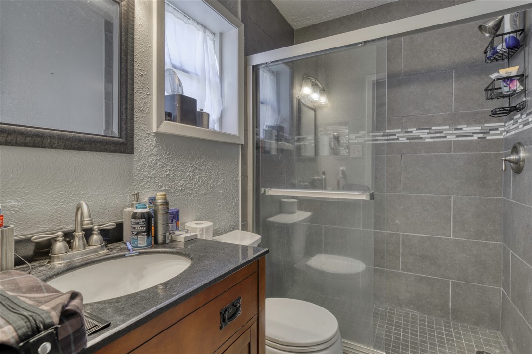 1410 Clement Court College Station, TX 77840 - Photo 9 of 16 a bathroom with a granite countertop sink a toilet a mirror and shower