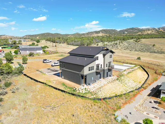 a kitchen with stainless steel appliances granite countertop a stove a refrigerator a sink a dining table and chairs with wooden floor