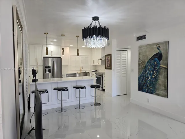 a kitchen with stainless steel appliances refrigerator and chairs