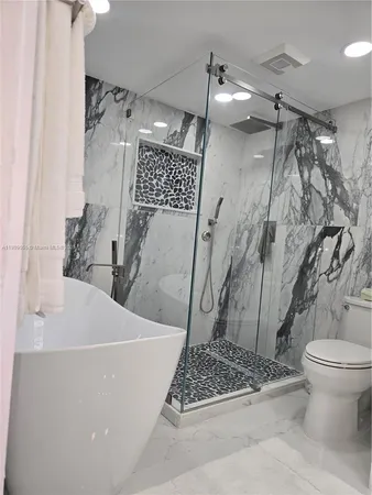 a kitchen with stainless steel appliances kitchen island granite countertop a stove a sink and a microwave