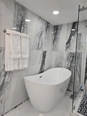 a white bath tub sitting next to a white sink and vanity