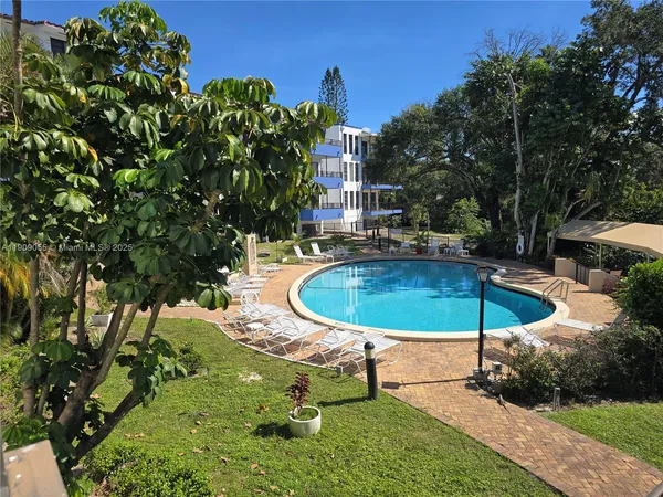 a view of a swimming pool with a table and chairs under an umbrella