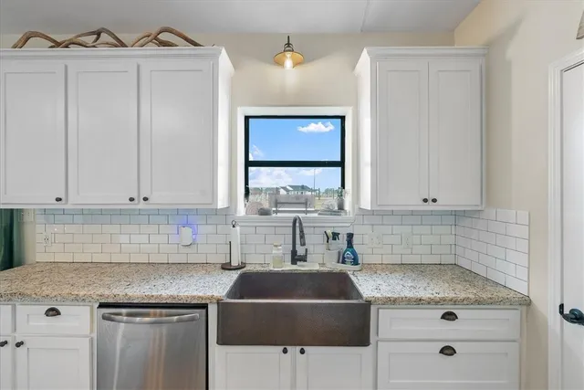 a kitchen with granite countertop a sink stove and cabinets