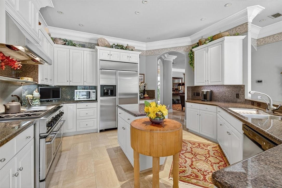 4811 Ocean Drive Corpus Christi, TX 78412 - Photo 9 of 39 a kitchen with stainless steel appliances kitchen island granite countertop a sink dishwasher stove and refrigerator with wooden floor