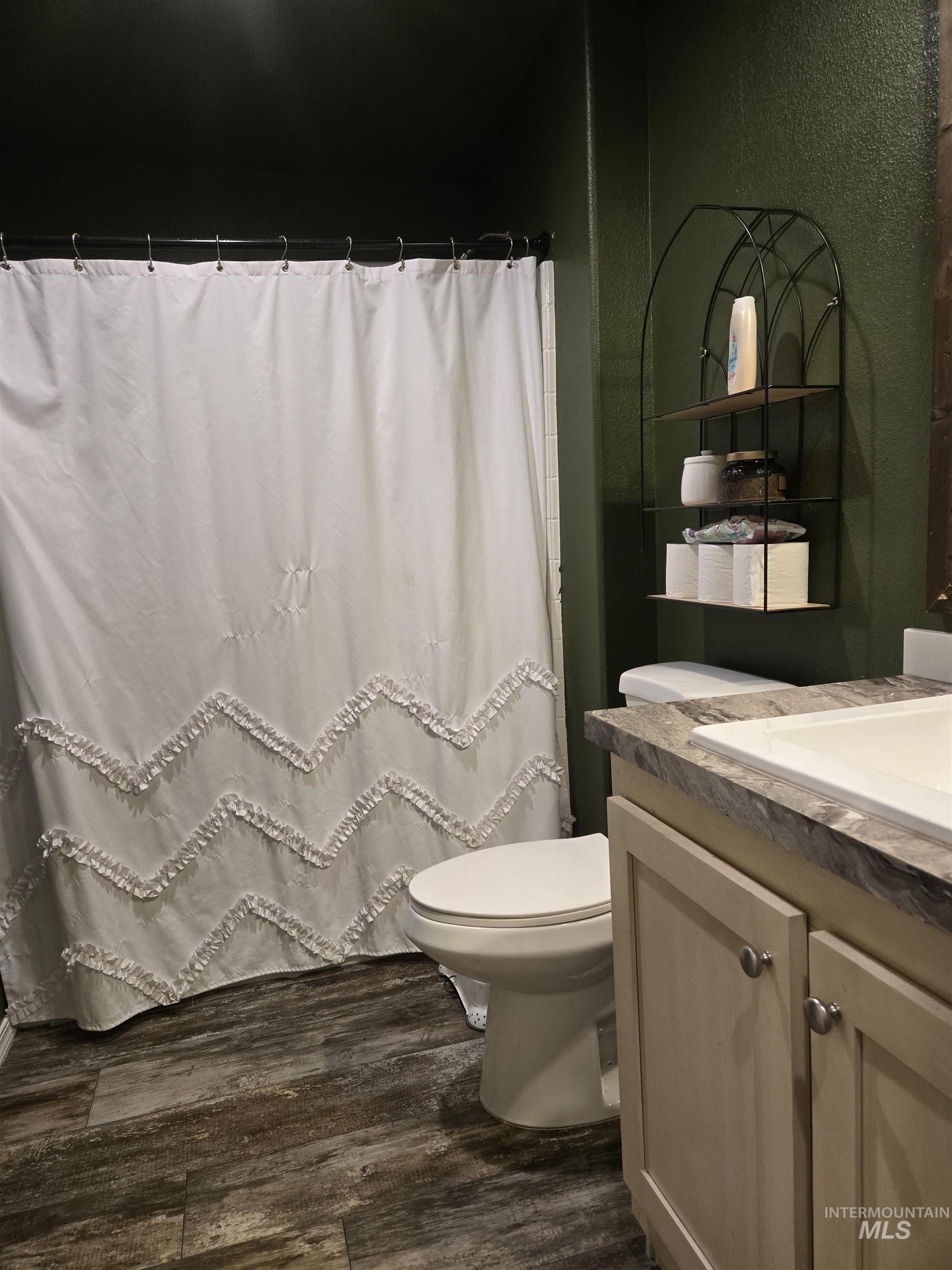 174 Konkolville Road Orofino, ID 83544 - Photo 22 of 43 Bathroom featuring a shower with a white curtain, a white toilet, and wood-finish flooring