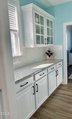 a kitchen with granite countertop white cabinets and a sink