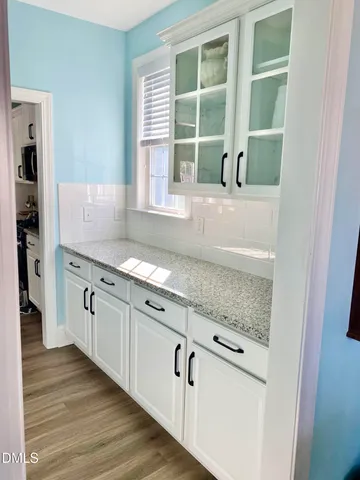 a kitchen with stainless steel appliances granite countertop a stove top oven a sink a dining table and chairs