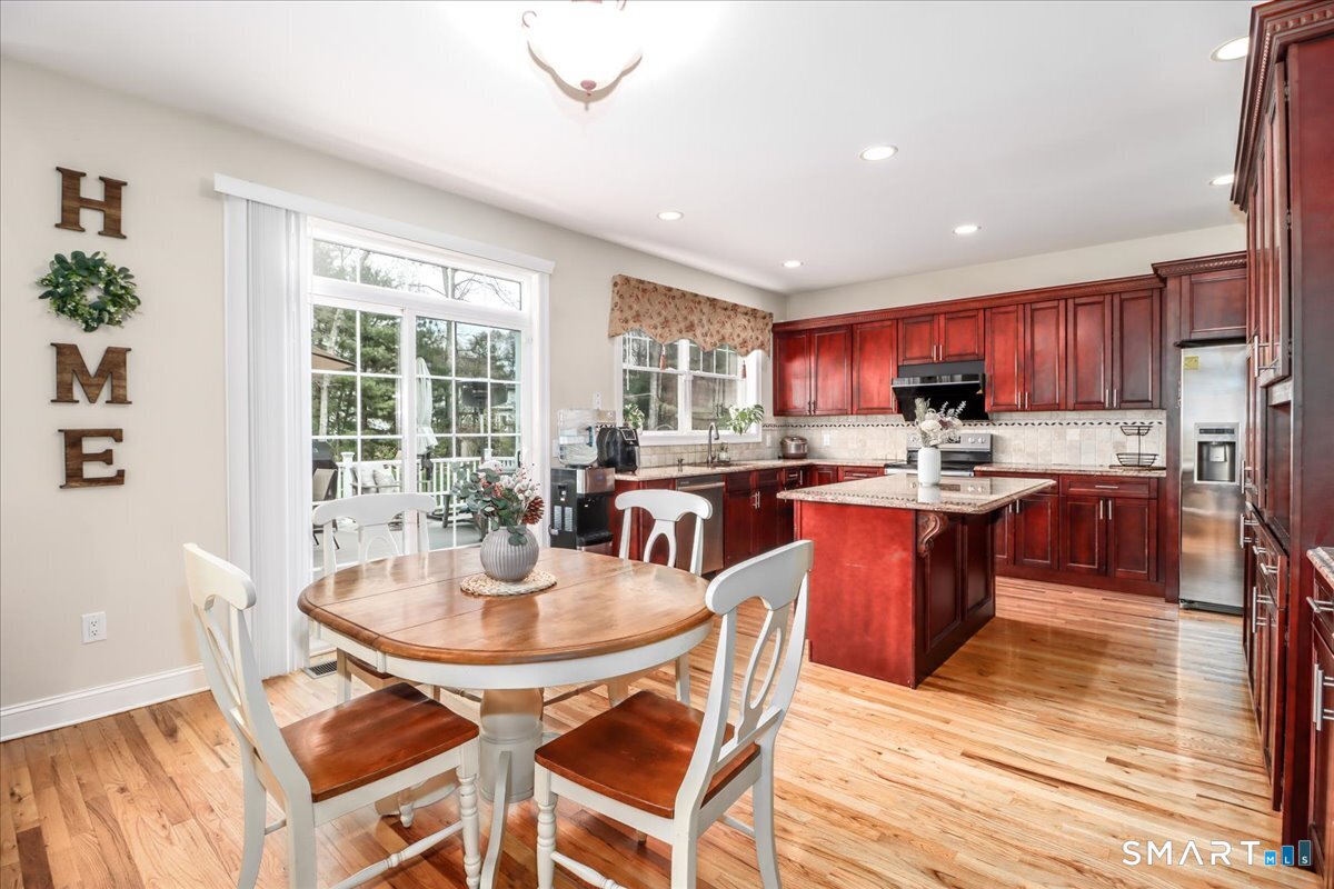 21 Pearl Street Newtown, CT 06482 - Photo 18 of 39 a open kitchen with stainless steel appliances granite countertop a stove a refrigerator a kitchen island a table and chairs
