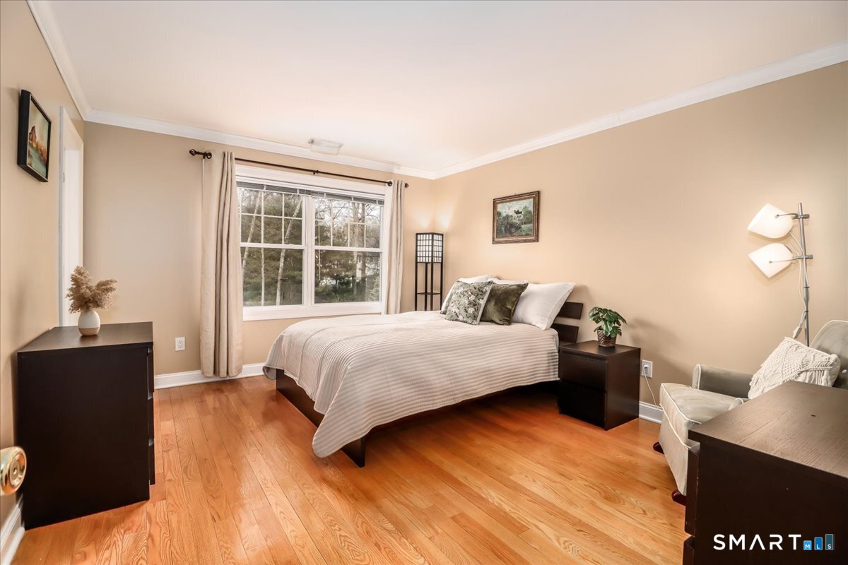 21 Pearl Street Newtown, CT 06482 - Photo 28 of 39 a bedroom with a bed and wooden floor