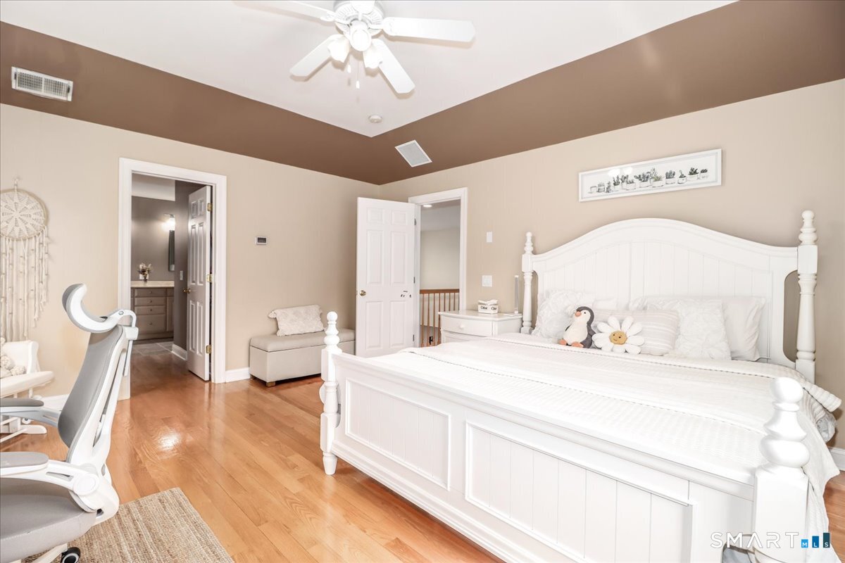 21 Pearl Street Newtown, CT 06482 - Photo 36 of 39 a spacious bedroom with a bed and a chandelier