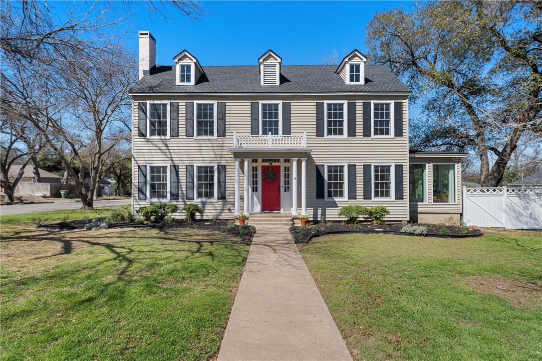 front view of a brick house with a yard