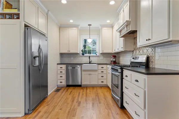 a kitchen with white cabinets and stainless steel appliances