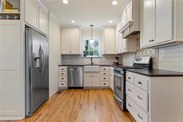 a kitchen with white cabinets and stainless steel appliances