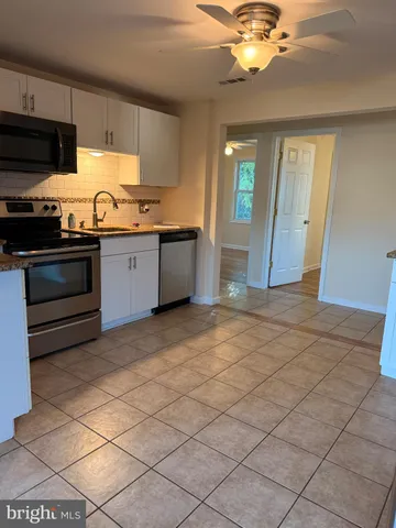 a kitchen with granite countertop a sink cabinets and stainless steel appliances