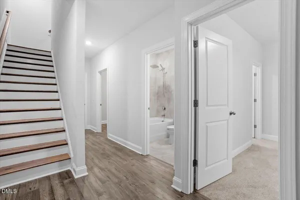 a view of a hallway with wooden floor and entryway