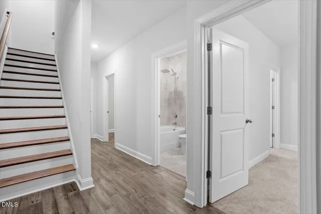 a view of a hallway with wooden floor and entryway