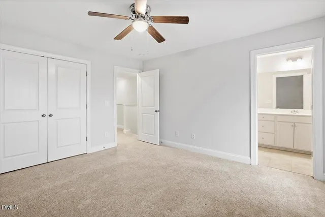 an empty room with closet and a chandelier fan