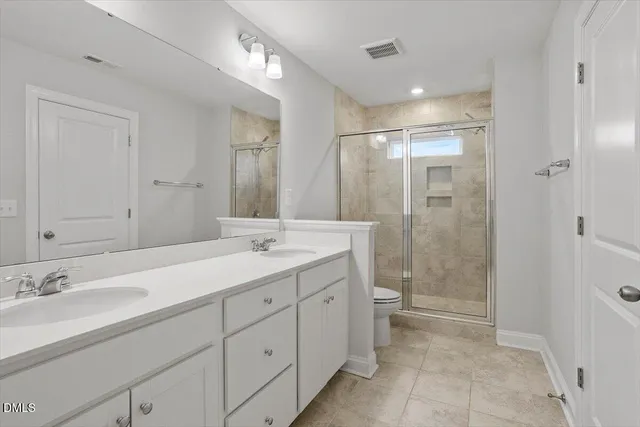 a bathroom with a double vanity sink mirror and toilet