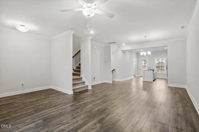 a view of an empty room with wooden floor and a fireplace