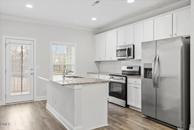 a kitchen with stainless steel appliances granite countertop a stove a sink and a refrigerator
