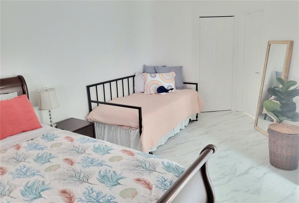 2903 63rd Street West Bradenton, FL 34209 - Photo 12 of 22 a bedroom with a bed and a flat tv screen on dresser