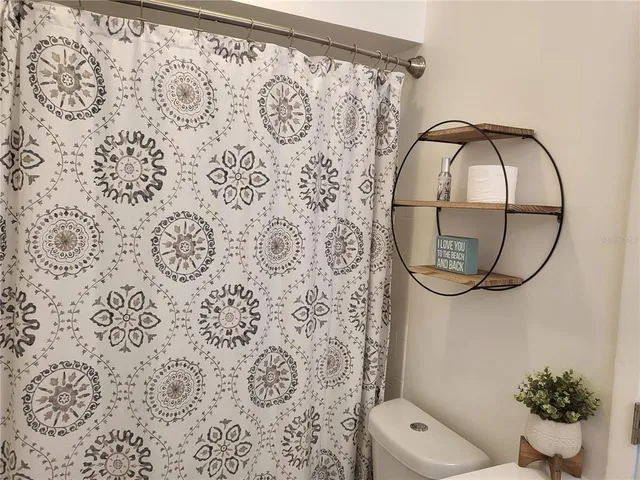 a bathroom with a toilet and a shower curtain