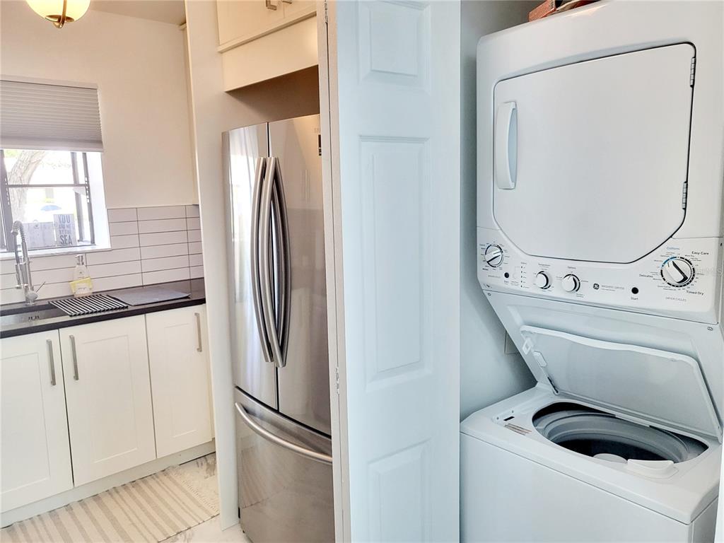2903 63rd Street West Bradenton, FL 34209 - Photo 5 of 22 a view of washer and dryer with kitchen in the background