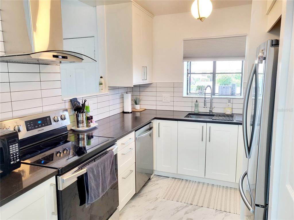 2903 63rd Street West Bradenton, FL 34209 - Photo 6 of 22 a kitchen with a sink stove and cabinets