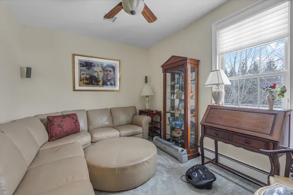 a living room with furniture a flat screen tv and a large window