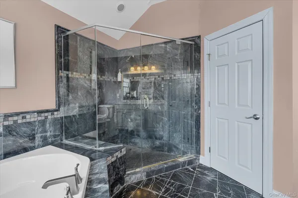 a bathroom with a granite countertop bathtub shower and sink