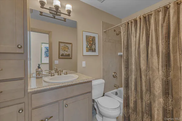 a bathroom with a toilet a sink a mirror a vanity and window