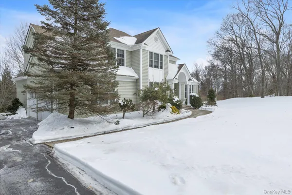 a view of a white house with a yard covered in snow