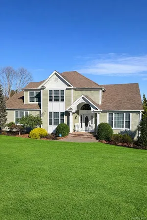a front view of a house with a yard and trees