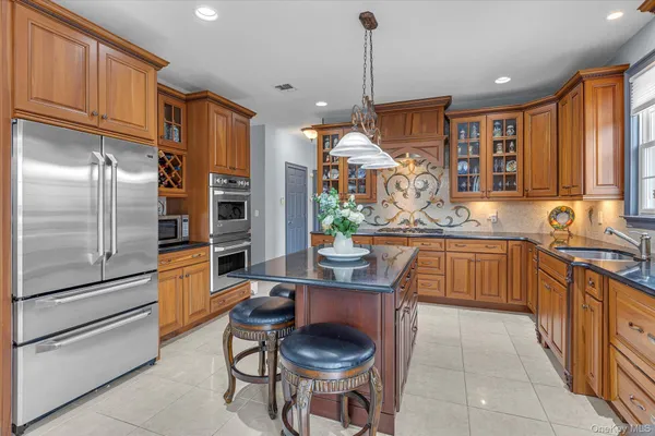 a kitchen with stainless steel appliances granite countertop a sink a stove and a refrigerator