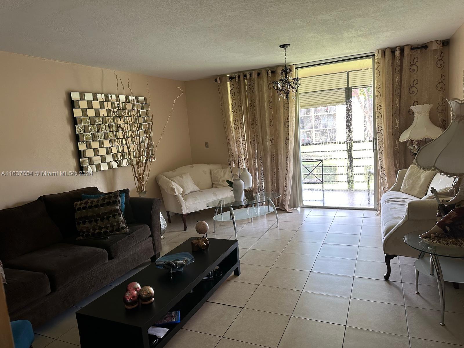 3195 Foxcroft Road, Unit F205 Miramar, FL 33025 - Photo 3 of 17 a living room with furniture and a window