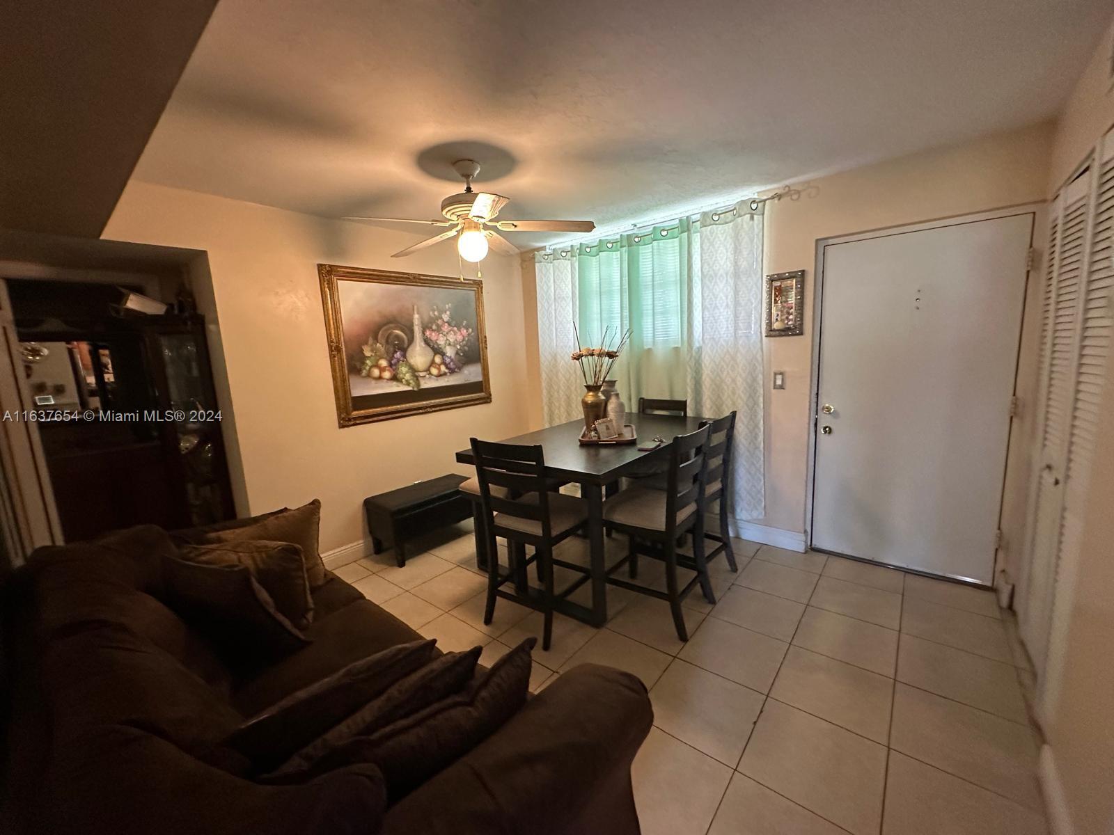 3195 Foxcroft Road, Unit F205 Miramar, FL 33025 - Photo 6 of 17 a living room with furniture a ceiling fan and a window