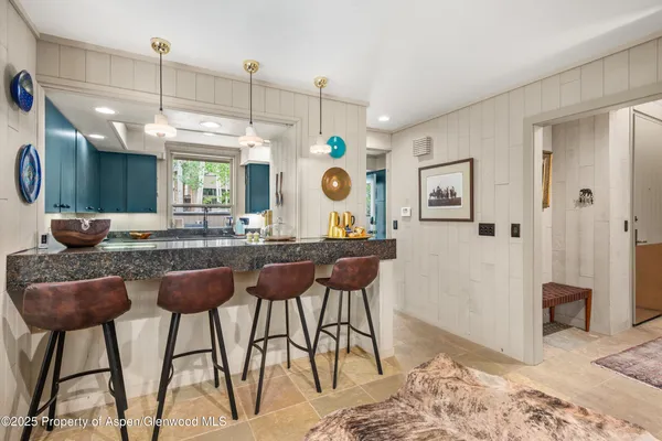 a kitchen with kitchen island granite countertop a sink cabinets and stainless steel appliances