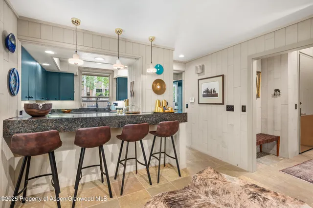 a kitchen with kitchen island granite countertop a sink cabinets and stainless steel appliances